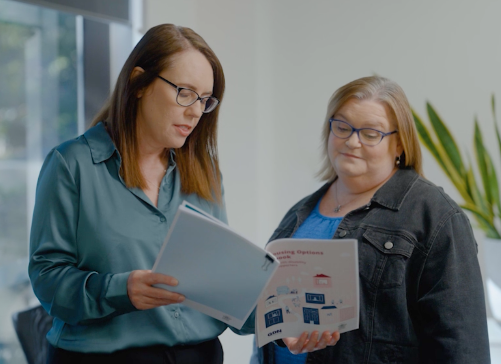 Two people looking at workbook resources.