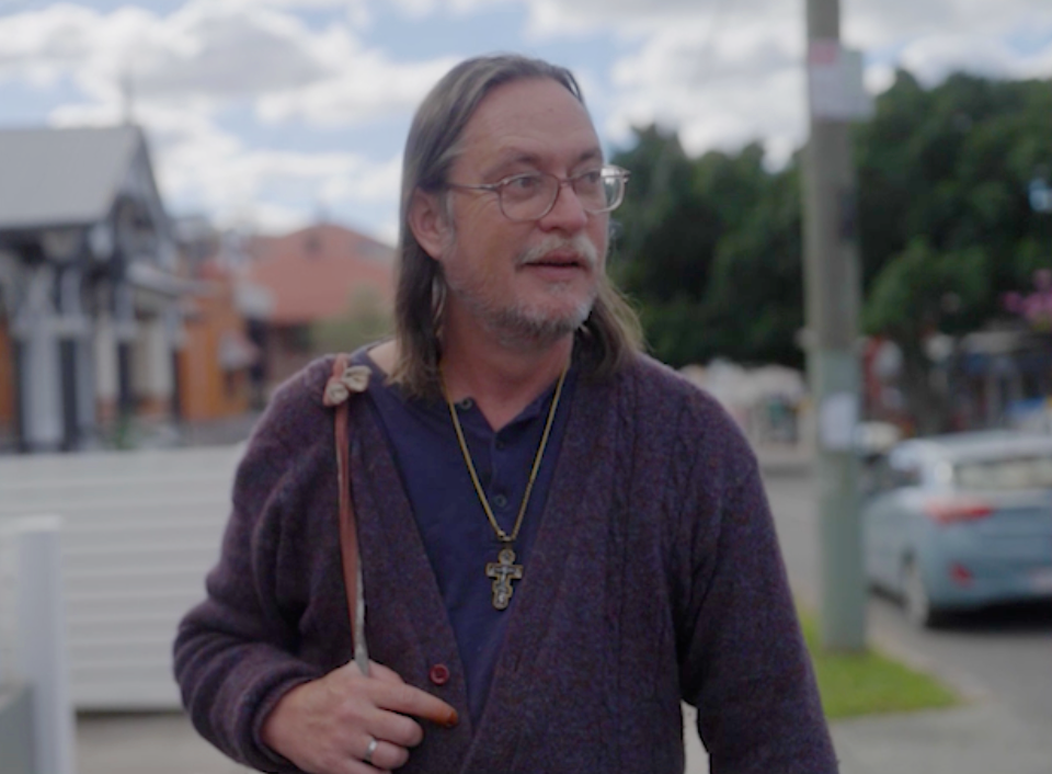 A man walking down the street in front of some houses.